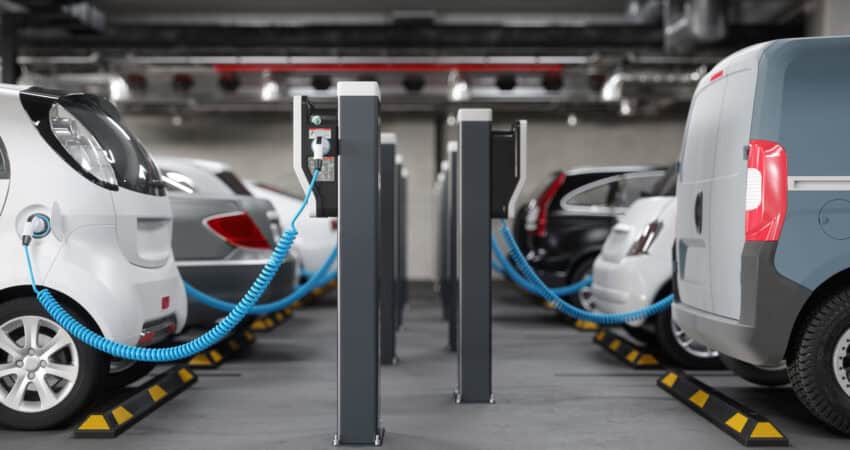 Side view of charging electric cars in a parking garage. Clean energy, networking connectivity, EV charger fleets