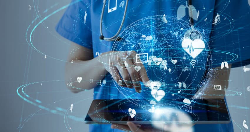 Medical IoT concept photo showing a healthcare provider summoning up medical data on a tablet device.