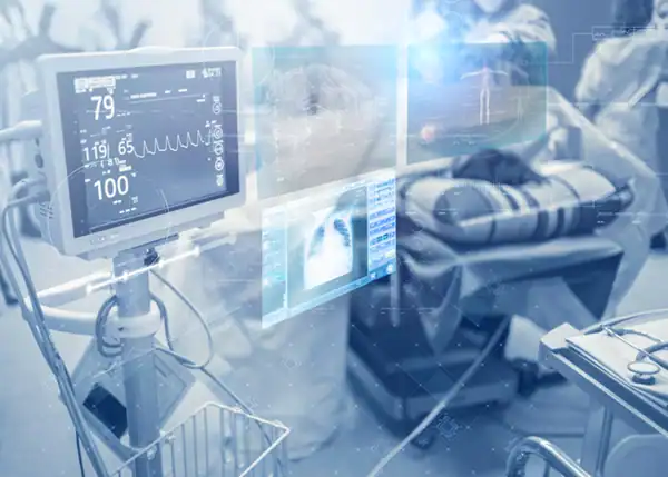 Hospital bed surrounded by monitoring equipment ad dashboards..