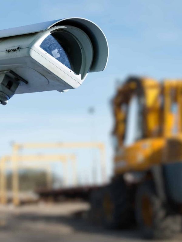 CCTV security camera on a construction job site with a backhoe in the background of the photo